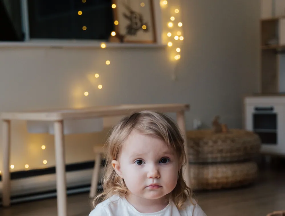A toddler playing with wooden blocks on the floor